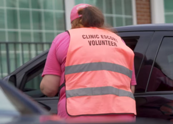 A pro-abortion escort stands outside a Philadelphia Planned Parenthood.