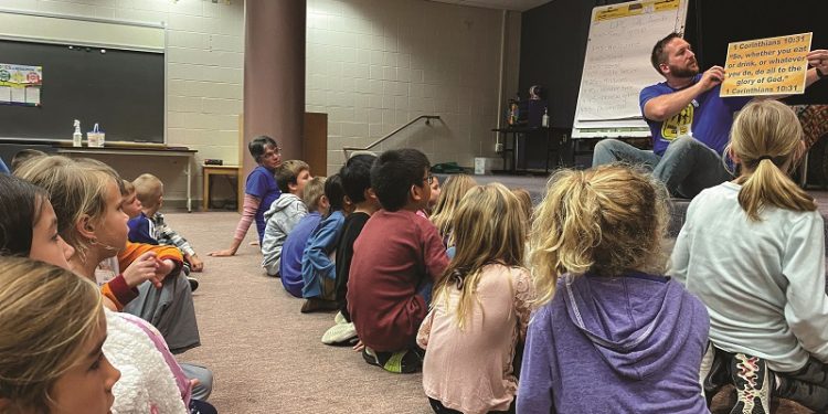 Volunteer Brad Esbenshade leads the children at Landisville Primary Center’s Good News Club in learning 1 Corinthians 10:31.