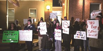 Protesters hold signs outside Rep. Bryan Cutler's constituent meeting Jan. 26 at the Strasburg Township Municipal Building.