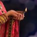 Stock image of woman holding oil lamp during Diwali, a Hindu festival.