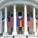 A Pride Progress flag hangs on the White House between two American flags.